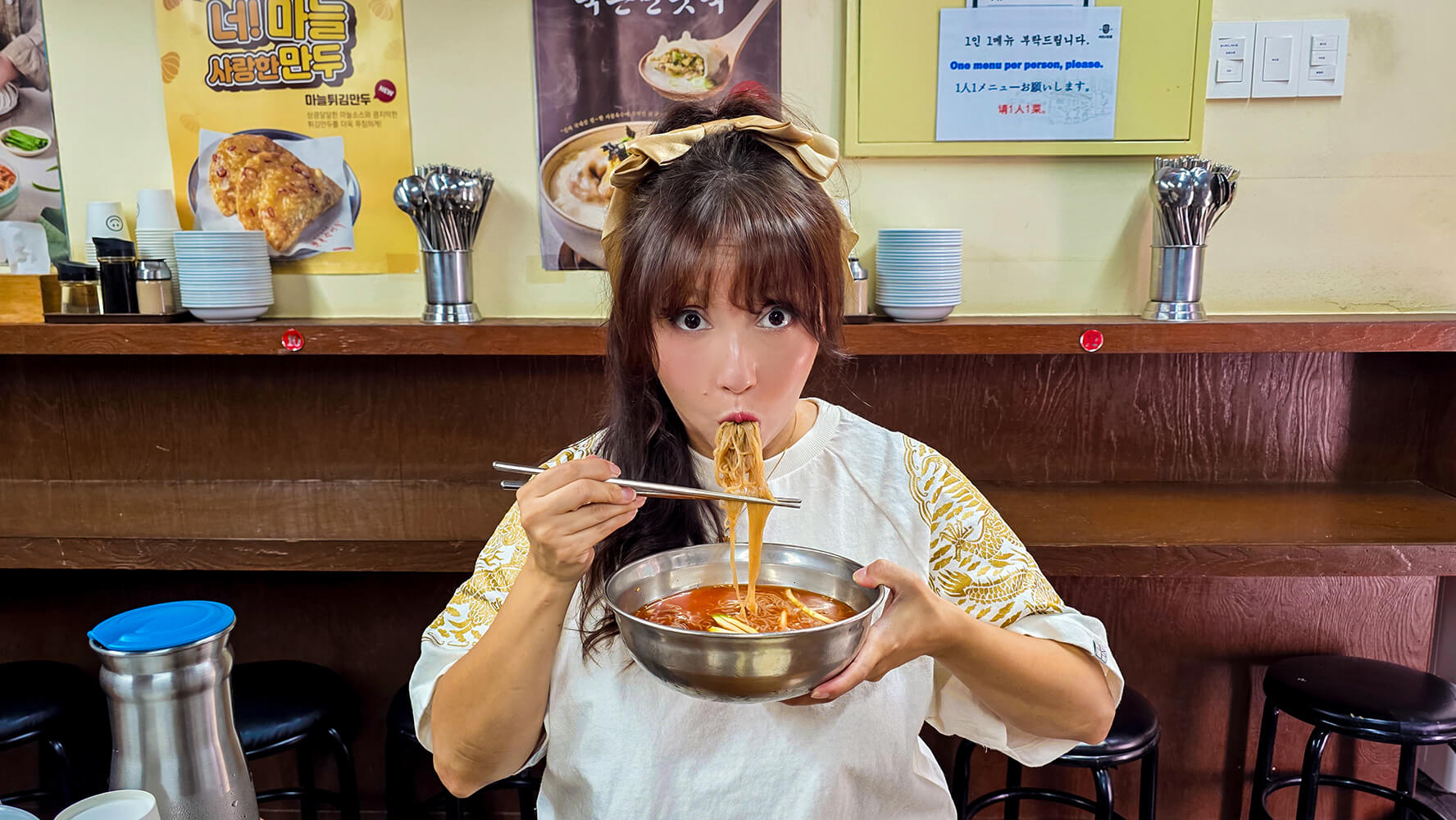 woman eating a bowl of cold noodles or naengmyeon